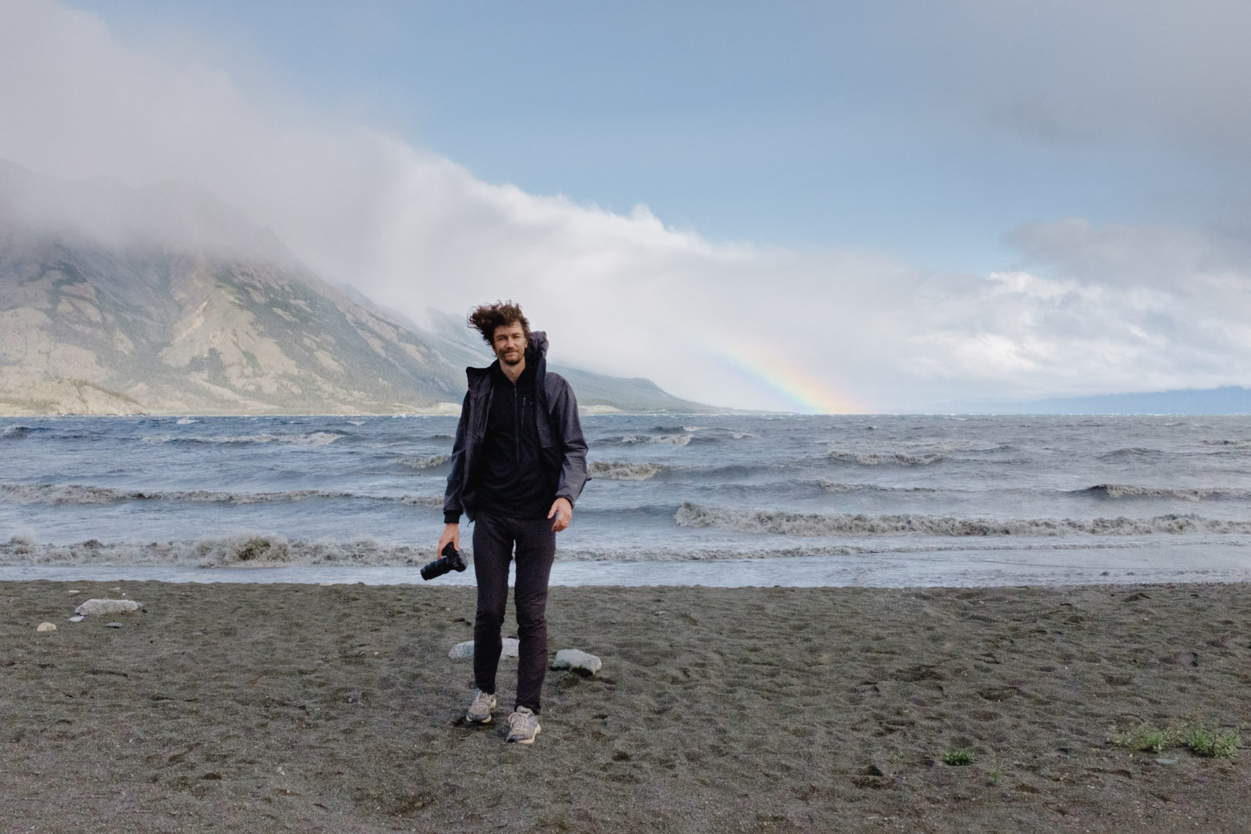 Man with camera walking on beach